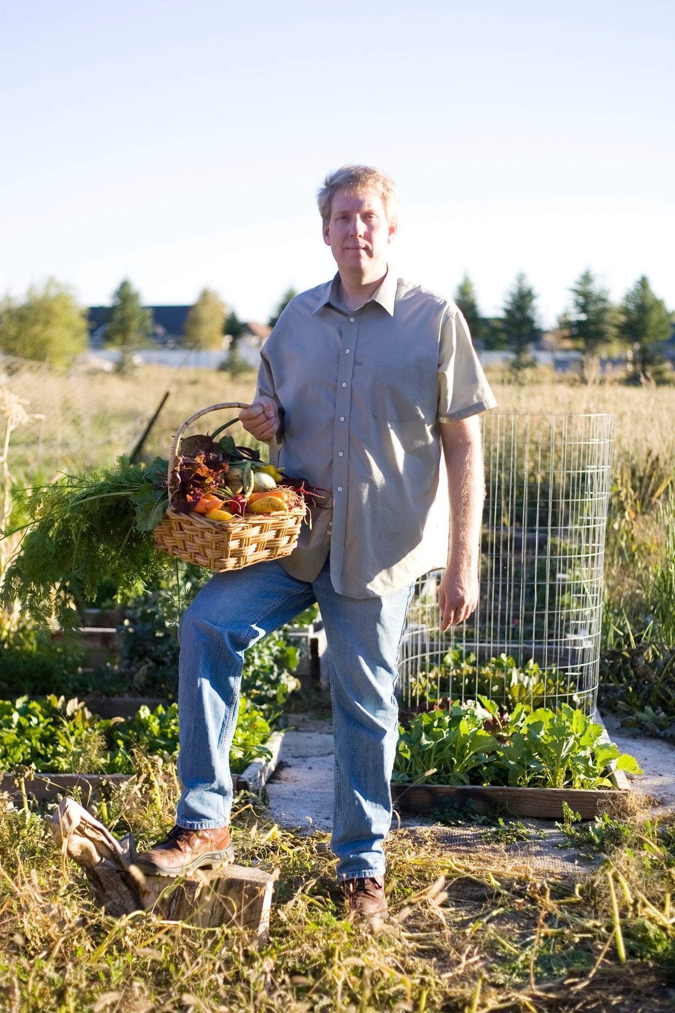 Photo of Caleb Warnock holding a basket of fresh produce in a field