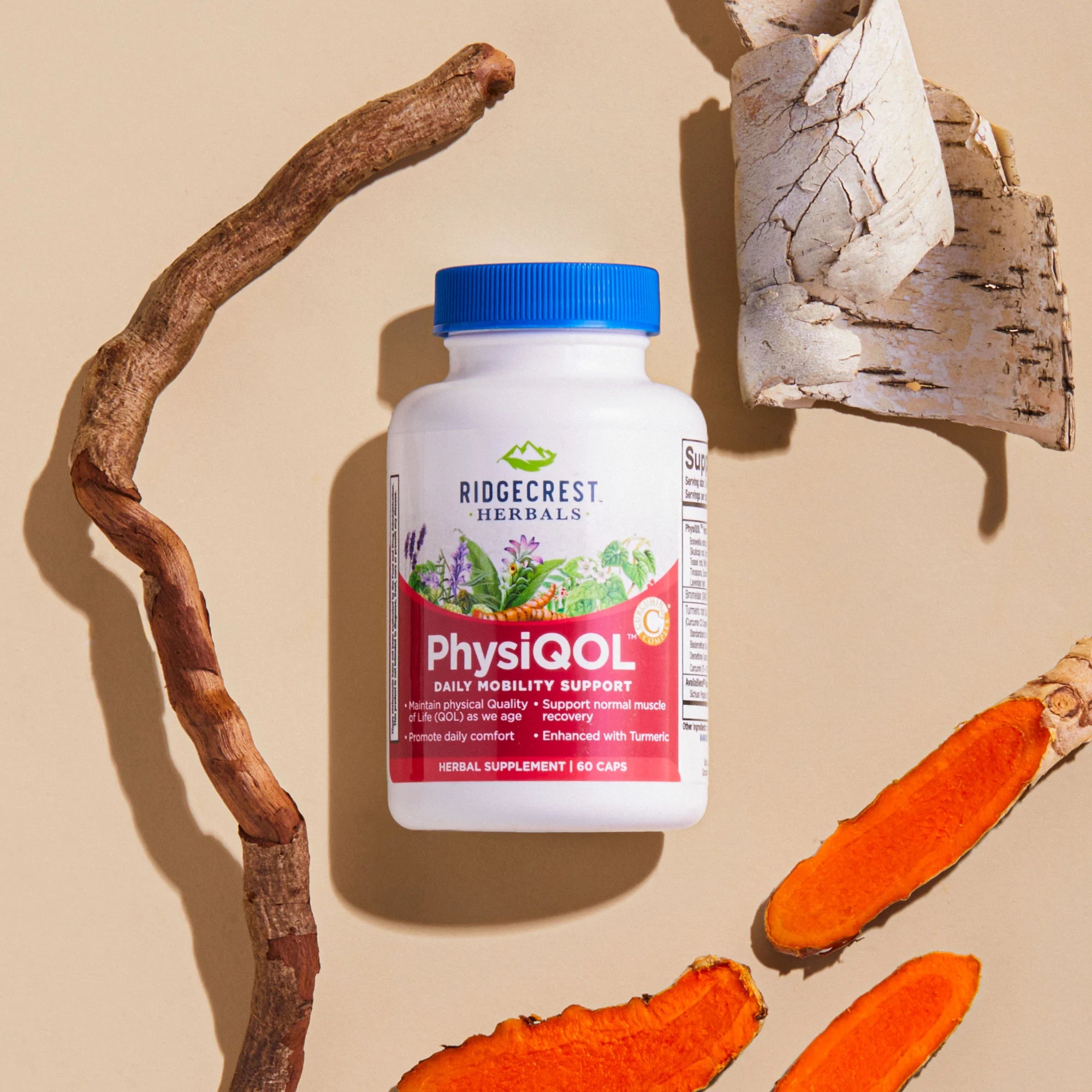PhysiQOL supplement bottle surrounded by turmeric, tree bark, and root pieces on a beige background.
