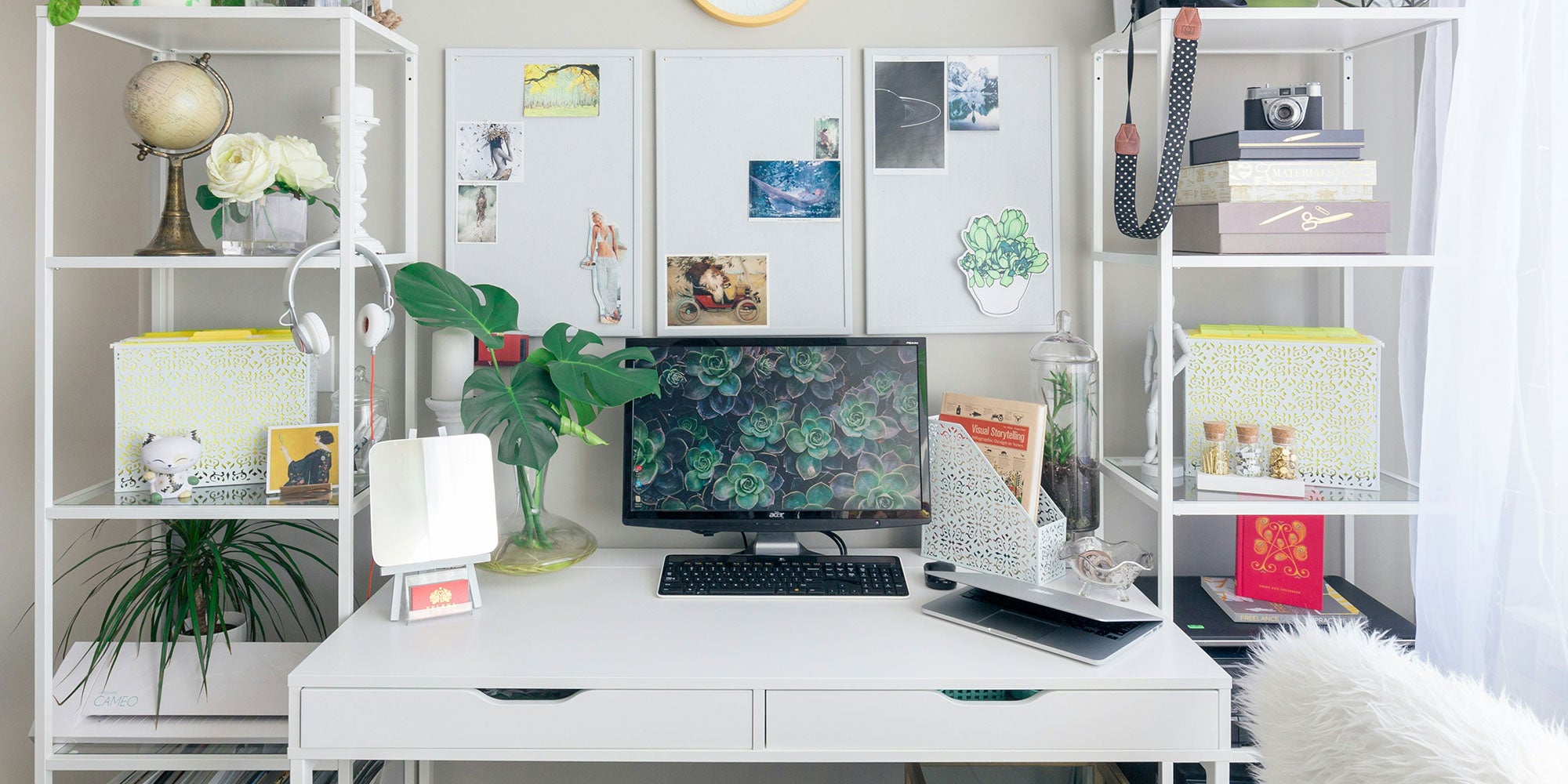 Photograph of a home office setup with computer, whiteboards, shelves, and knicknacks.