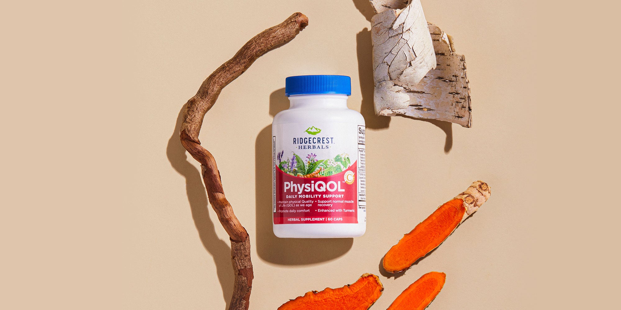 PhysiQOL supplement bottle surrounded by turmeric, tree bark, and root pieces on a beige background.