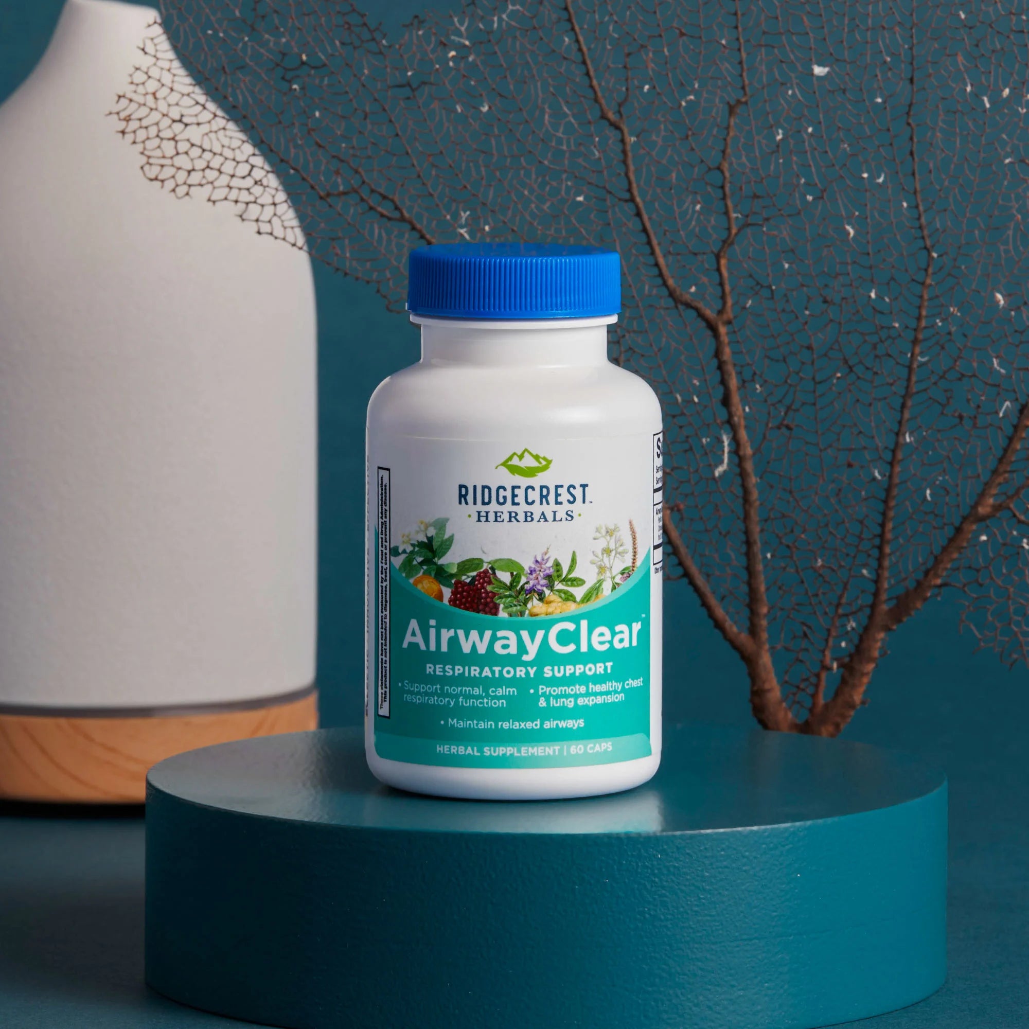 AirwayClear supplement is displayed with a white diffuser and dried branches, set against a teal background.