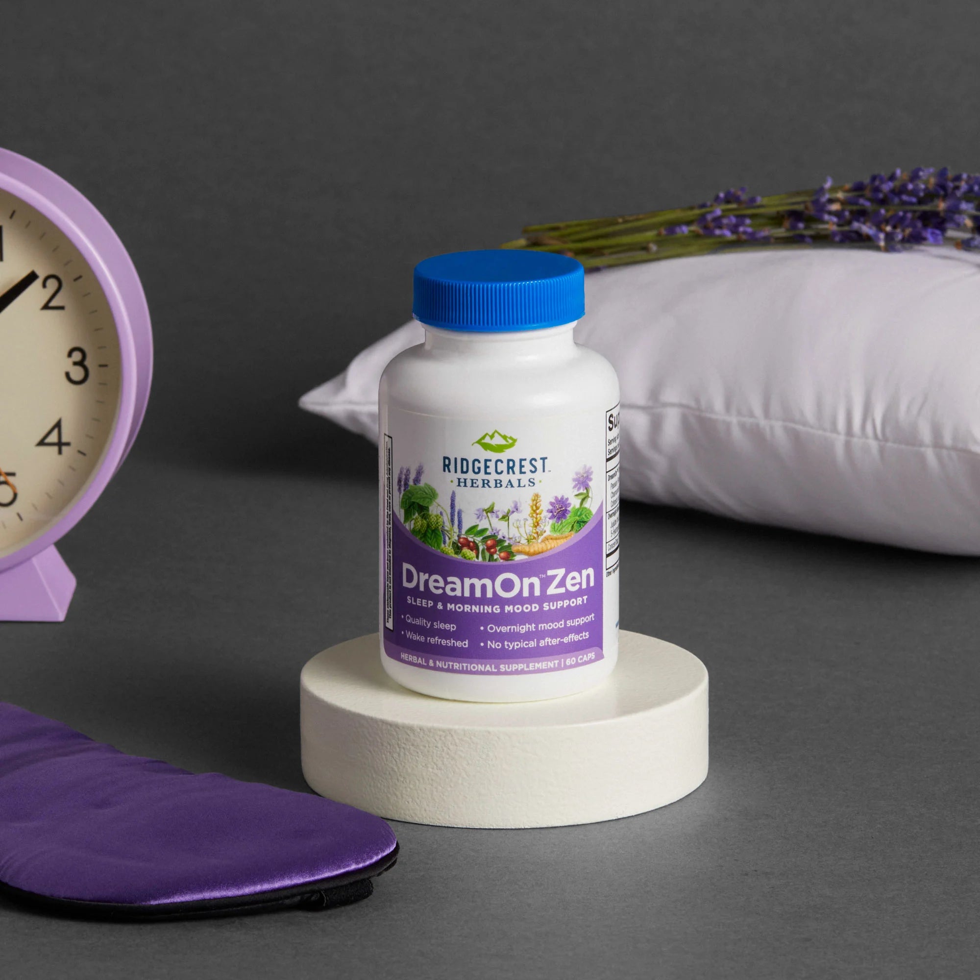 DreamOn Zen supplement is displayed with a lavender sleep mask, a pillow, a clock, and sprigs of lavender, set against a gray background.