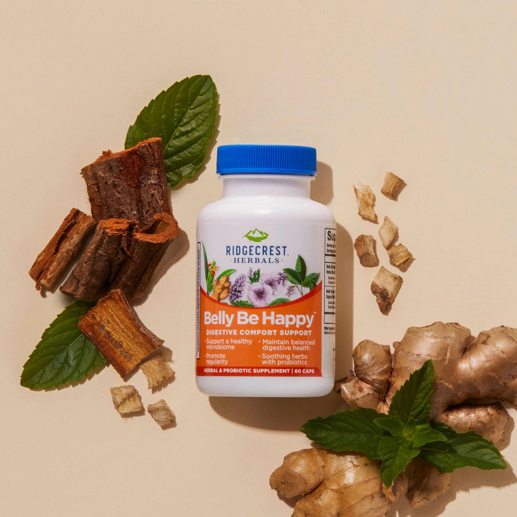 Belly Be Happy supplement on cream backdrop, surrounded by ginger root, peppermint, marshmallow, and slippery elm. 